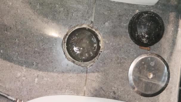 Výhled na otevřený trám v koupelně domu. Instalatér tlačí drenážní tyč a snaží se odemknout kanalizační vedení — Stock video