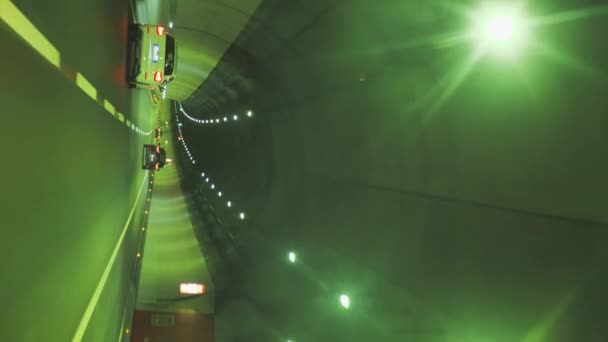 Coches borrosos que conducen a través de un túnel de montaña en Italia. Tráfico con líneas brillantes de alta velocidad. paisaje natural, vídeo vertical — Vídeo de stock