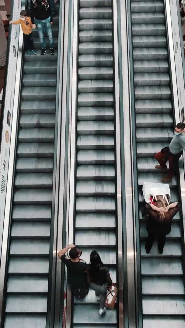 Alışveriş merkezinde yürüyen merdiven. İnsanlar yürüyen merdivenden iniyor. Yürüyen merdivende yürüyen isimsiz insanlar. Alışveriş merkezinde müşteriler yürüyen merdiven kullanır.. — Stok video