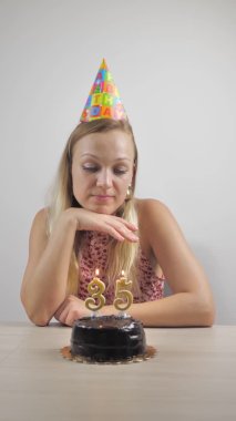 Kadın doğum günü için mumları üflüyor. dikey video