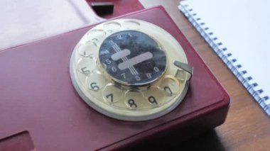 Üst manzara, numarayı arayan bir adamın eli. Eski model sabit telefon.