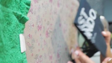 Kadın elleri ütü masasında ütüyle giysileri ütülüyor. dikey video