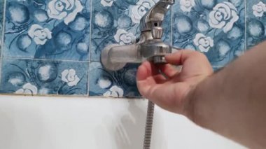 The plumber installs the aerator in the water tap in the bathroom.
