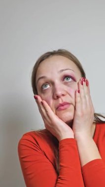 dikey video. Gözünün altında çürük olan kadın telefonda SMS yazıyor. Kadınlara şiddet