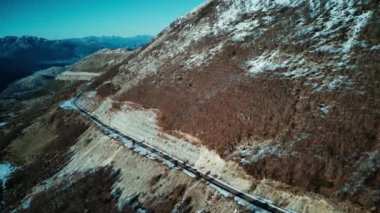 Kış manzarasında hava uçuşu. Arabalar kışın dağların arasında karlı bir yolda ilerliyorlardı. İtalya dağ gezisi, Ambruzzo. Drone görüntüle.