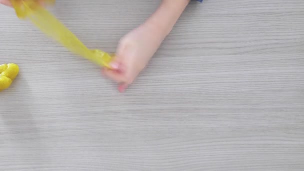 Hand Playing with textured slime with bubbles, stretching the gooey substance. teen hand holding green shining slime, squeezing it. stretching slime toy to the sides. Liquid toy. — Stock Video
