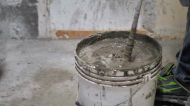 Yapıştırıcıyla karıştırıyorum. Bir karıştırıcıyla beton inşa etme hazırlığı.