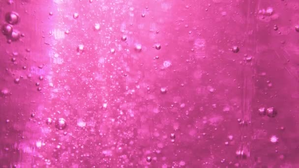 Rózsaszín kozmetikai gél apró buborékok emelkedik a tetejére. — Stock videók