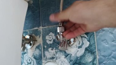 Tesisatçı su hortumunu sıkıyor, su tankını boşaltıyor.