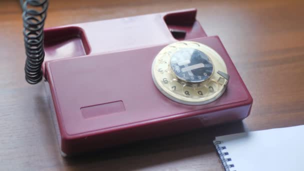 Close up de telefone fixo vintage na mesa de madeira velha. Mão é número de discagem, decoração de parede à moda antiga — Vídeo de Stock