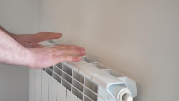 L'uomo si scalda le mani da un termosifone — Video Stock