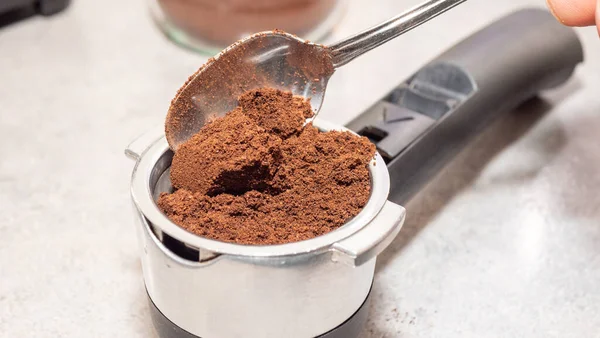 Mans hand preparing ground coffee for brewing aromatic espresso coffee