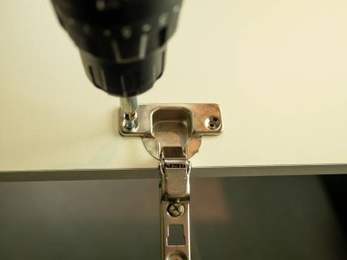 Usta mobilya detaylarına aksesuar takar. Dolap mobilyalarının montajı