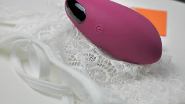 Vibrador roxo em um fundo branco. Treinadora de músculos feminina. Ovo vaginal para treinamento vaginal. Dispositivos de saúde das mulheres. Coisas íntimas para a sexualidade das mulheres — Vídeo de Stock