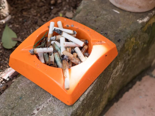 Homme fumant une cigarette et utilisant un cendrier — Photo