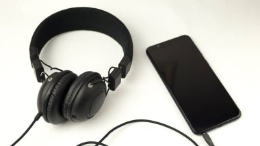Kulaklık ve akıllı telefon beyaz arkaplanda izole edildi