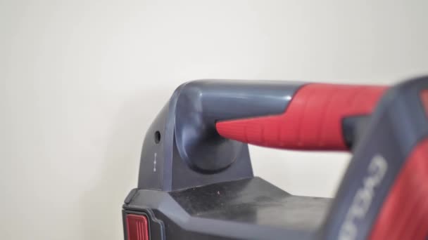 The man inserts the plug of the charger into a vacuum cleaner with a battery. — Vídeo de Stock