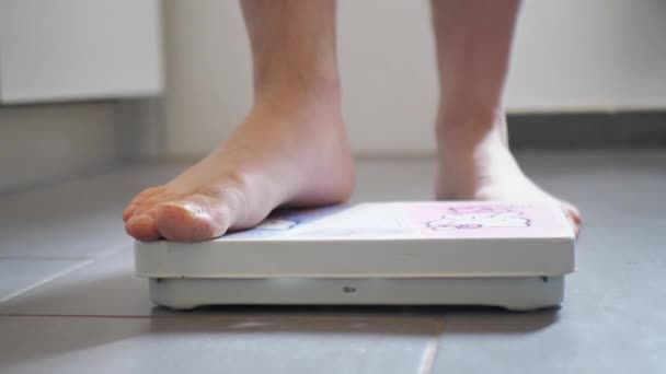 The man gets on the scales. Weighing on scales. Close-up of male legs on the scales, Excess weight check 4k — Video Stock