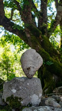 Beyaz duvar kağıtlı taş piramit, doğanın arka planında.