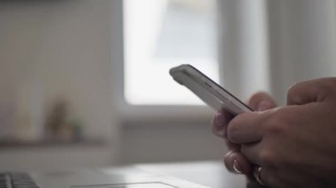Close up side view millennial woman holding cellphone, swiping photos in online dating app. Young girl ordering food taxi in mobile application
