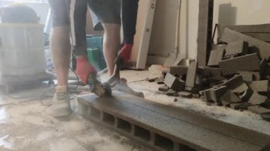 The workman cutting concrete blocks by diamond circular saw blade