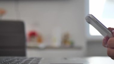 businesswoman sitting in modern office texting on smartphone, sharing success messages on social media. Attractive happy business freelancer reading good news on the phone