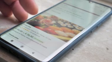 Man holding phone with sushi delivery app on screen, technology lifestyle concept