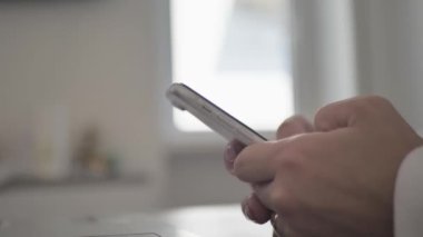 Close up side view millennial woman holding cellphone, swiping photos in online dating app. Young girl ordering food taxi in mobile application