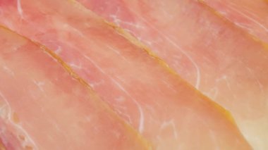 Jamon or dry-cured ham produced in Spain texture close up. 4K resolution Food background.