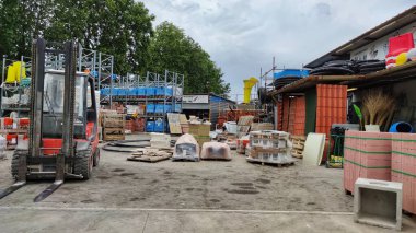 Sokaktaki bir inşaat deposunda yeni üretilen kırmızı tuğla paketleri. Onarım ve inşaat malzemeleri kavramı.