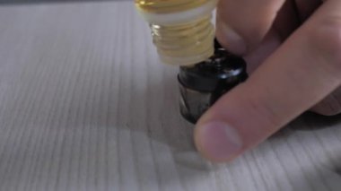 Elektronik bir sigaranın deposunu sıvıyla doldurmak..