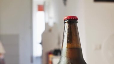 Mens hands open bottle of beer. Opening a brown beer bottle with an opener. Celebrating concept. Abuse and alcoholism concept