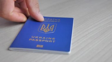 Ukrainian biometric passport for traveling in Europe on the table. Inscription in Ukrainian Passport of Ukraine. Travel or migrant concept