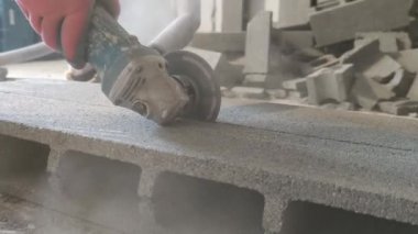 Cutting a big concrete block with circular machine.