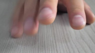 A man in a good mood taps his fingers in the rhythm On the table during rest.