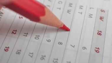 Wall calendar, the number of the month is crossed out. A hand crosses out the days on a paper calendar with a red pen. A very important date in the calendar. Signing the day in the calendar