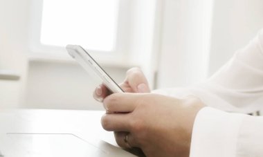 İş yerinde akıllı telefon, mesajlaşma, ürün ve hizmetleri online olarak seçme ve satın alma, modern teknoloji kullanımı kavramını kullanarak. Masada oturan cep telefonu tutan kadınların yakın plan fotoğrafları..