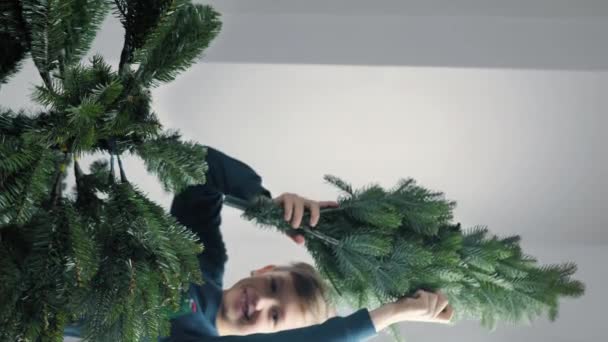 Boy Spreads Branches Christmas Tree Vertical Video — стоковое видео