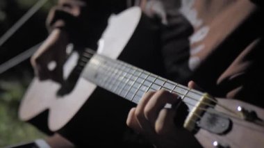 Playing the guitar at campfire. playing the guitar by the fire.