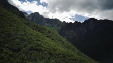 Aerial view of hillside in front of steep mountains, in Abruzzo, Italy - circular drone shot.