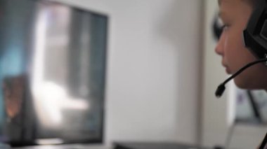 Bulanık evde bilgisayar oyunu oynayan bir çocuk. Çevrimiçi oyun teknolojisi konsepti. Genç bir çocuk nişancı video oyunu oynuyor. Video oyunlarına kumar bağımlılığı.