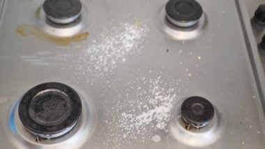 Gaz ocağını temizleyip düzenliyorum. Bir adam mutfakta parlayana kadar gaz sobasını deterjanla parlatır. Ev temizliği, temizlik ve düzen. Yüksek kalite 4k görüntü