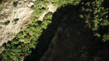 İHA, güneşli Abruzzo 'daki dağların arasından iniyor.