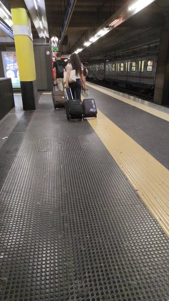 地下鉄でスーツケースを持ってる若いカップル 旅行のコンセプト — ストック写真
