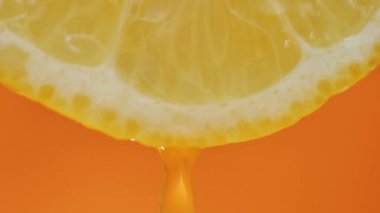 Limon suyu hamurdan akar ve portakal arkaplanına damlar, makro video. yavaş çekim