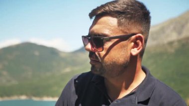 Bulanık bir tabiat geçmişi olan yetişkin bir adamın portresi, ormandaki arka planda gülümseyen bir adamın görüntüsü, yavaş çekim..