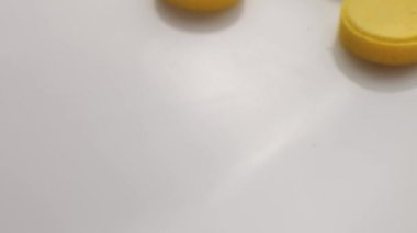 Close-up of many yellow pills spinning on a turntable.