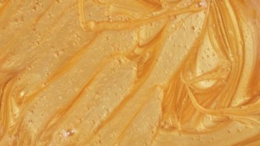 Erimiş altın yavaşça aşağı kayar. Makro atış. Işıltılı sıvı hareket