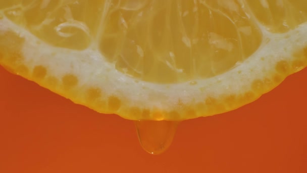 Лимонный Сок Течет Мякоти Капает Оранжевый Фон Макровидео Движение Слов — стоковое видео