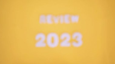 Yukarıdan çekilen sarı arkaplanda 2023 sayılı yazıt incelemesi bulanıklıktan berraklığa geçiş.